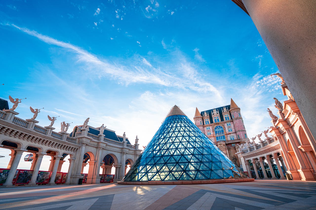 services-03 Iconic glass pyramid and arches at Ba Na Hills, Vietnam, under a vibrant blue sky.