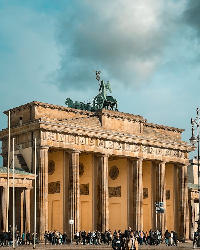 why-choose-us Iconic Brandenburg Gate in Berlin with a cloudy sky, a symbol of German history and architecture.